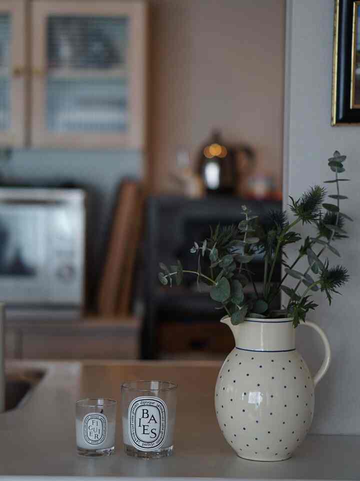 Beige-toned kitchen space featuring a polka-dot vase with greenery and candles, creating a natural and cozy atmosphere