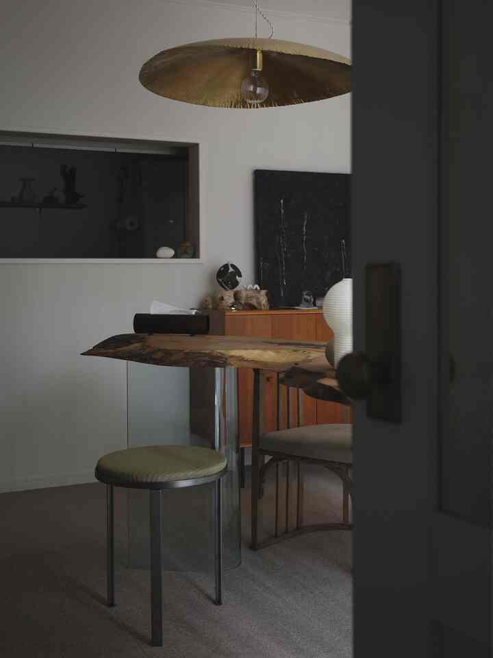 Natural modern kitchen space with brown and black tones, featuring a new iron stool and wooden table creating a stylish atmosphere