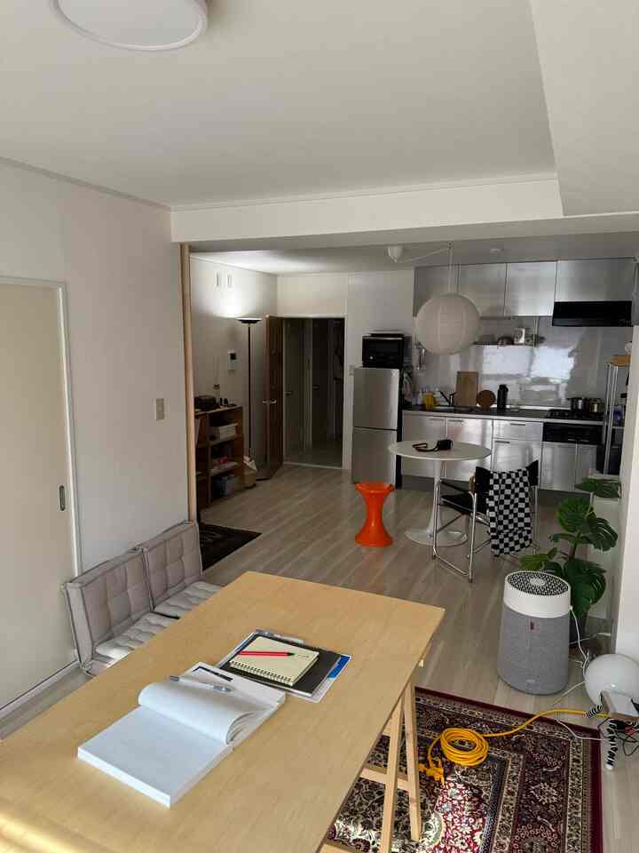 White and light brown toned single household living room with open kitchen, featuring minimal and simple modern style