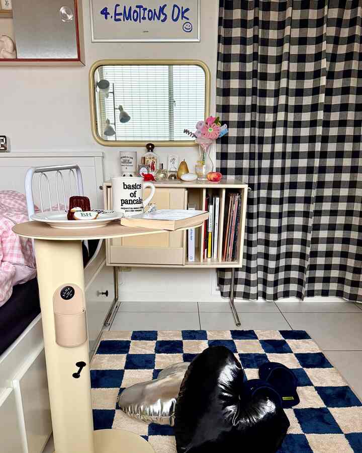 Beige and navy-toned bedroom featuring a side table and checkered rug, creating a cozy and stylish atmosphere