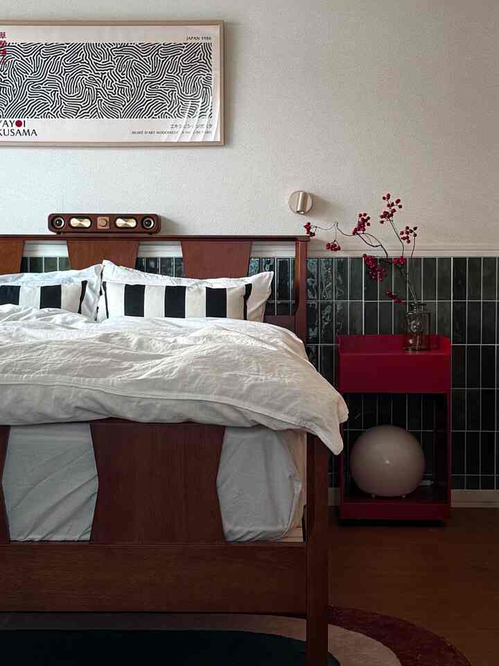 White and brown toned bedroom featuring wooden bed and red nightstand in a modern setting
