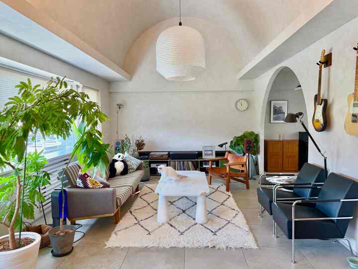 白を基調としたリビング、ソファとアームチェアが配置された落ち着いたモダンなインテリア