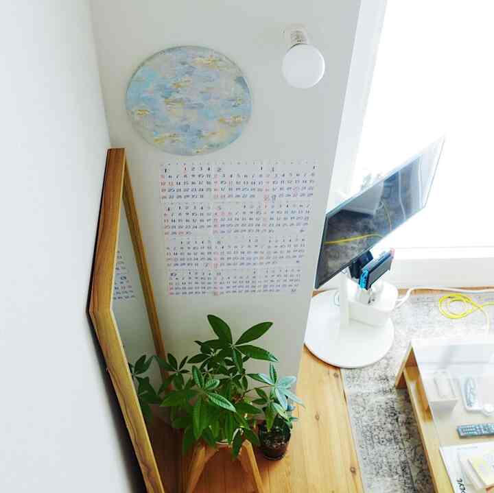 Bright natural-toned studio stairs area featuring wooden floor and large plants with a cozy atmosphere