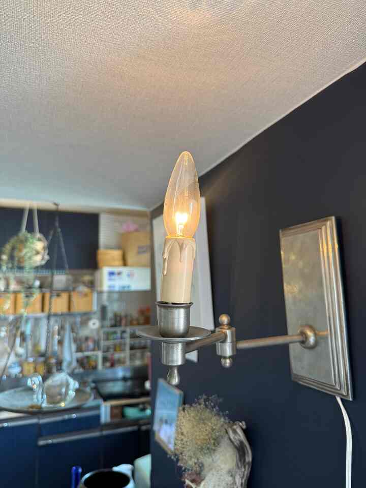 Kitchen space with silver wall sconce mounted on navy wall, cozy vintage atmosphere