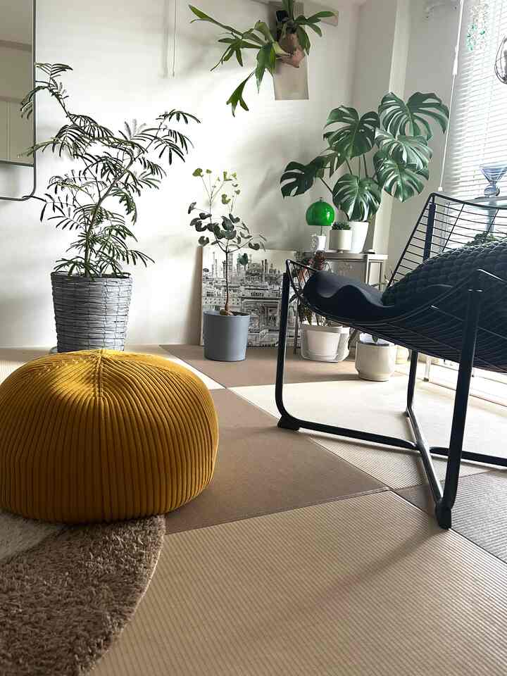Natural-toned tatami room featuring green plants and yellow pouf in a cozy Wa-Modern living space