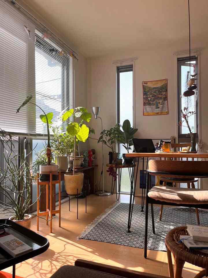 ナチュラルカラーと木製家具が調和した1LDKのリビングダイニング、広い窓と植物が印象的な空間