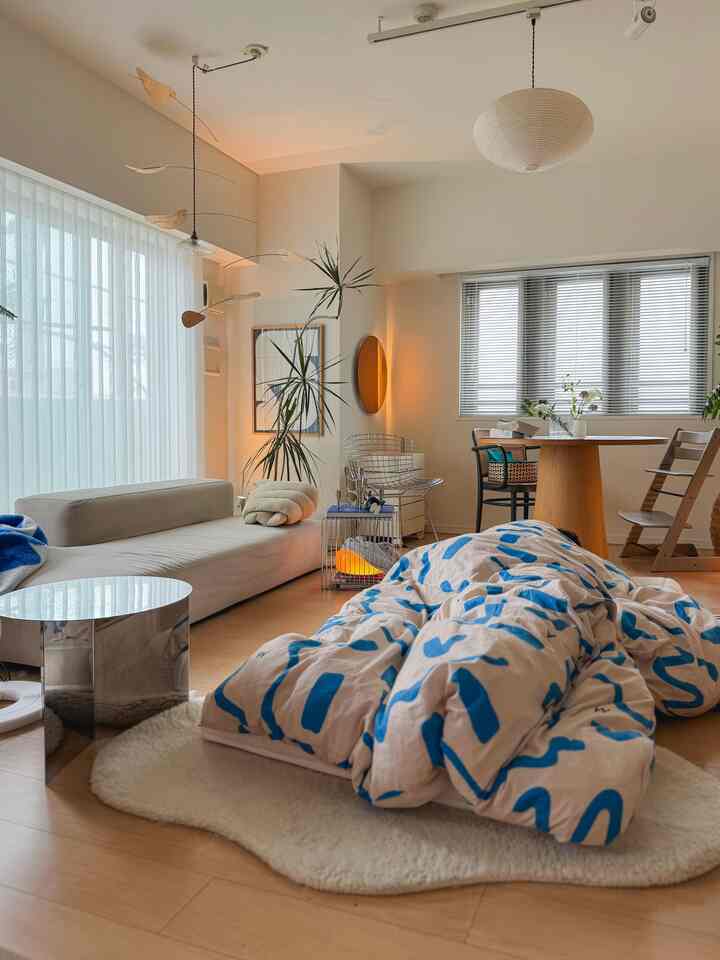 White and wood tone living room featuring a blue patterned duvet cover centrally placed, creating a cozy atmosphere