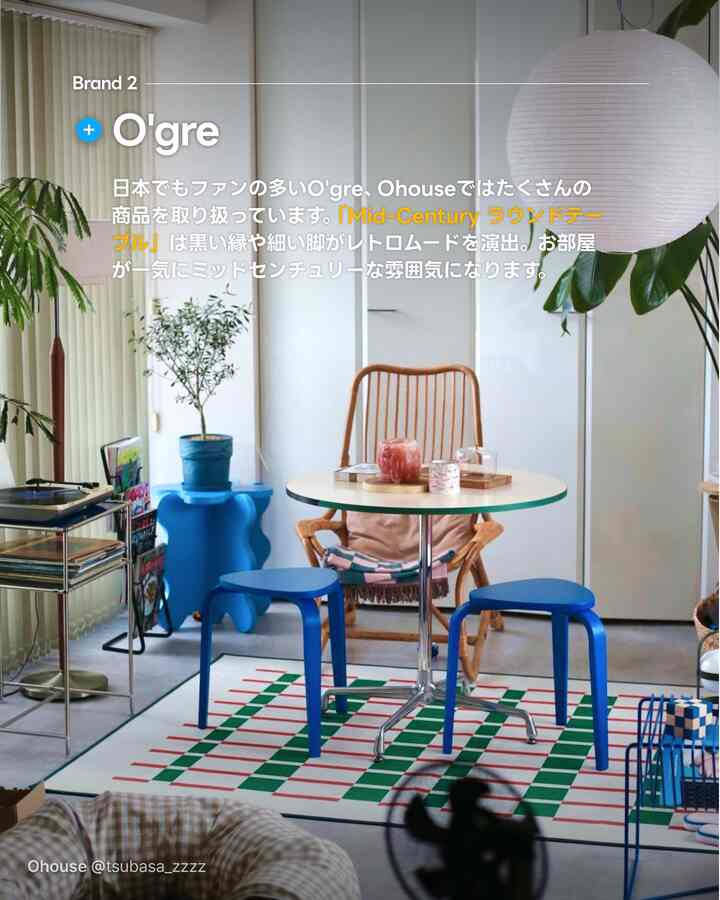 A white and blue toned dining room featuring a mid-century round table, rattan chair, and blue stools in a modern cozy space