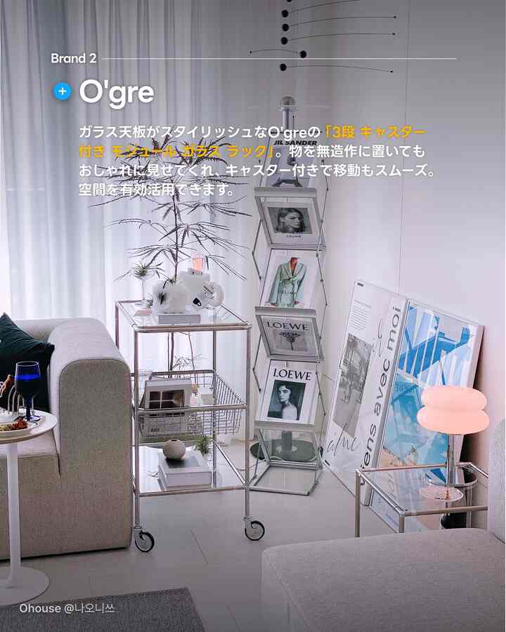 ホワイトとグレーのトーンで統一されたモダンなリビング、洗練された3段トロリーとアートフレームが配置された明るくスタイリッシュな空間
