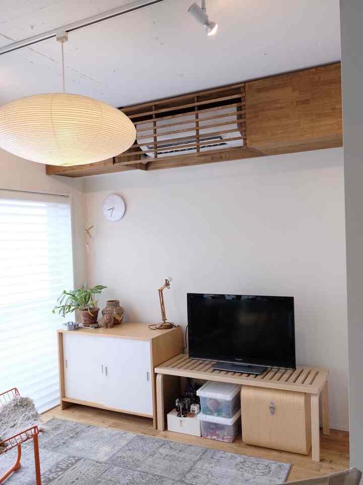 Bright white walled living room featuring wood tone furniture with a simple, natural atmosphere