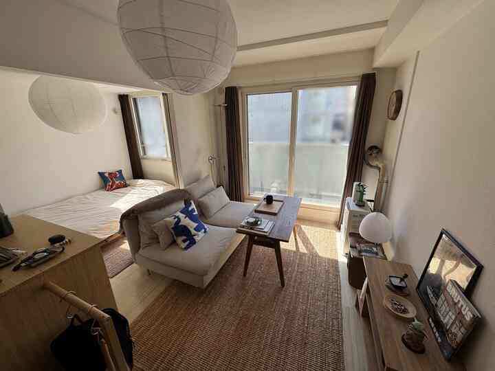 Natural-toned studio living room featuring cream sofa and wooden table with cozy atmosphere