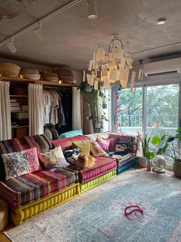 カラフルな色調のリビング、ヴィンテージ風のソファと植物が配置された温かみのある空間