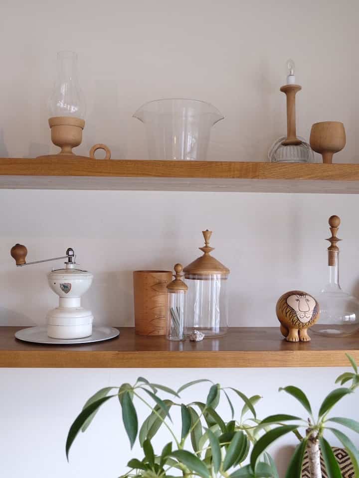 ナチュラルな色調のダイニング、木製と透明なガラスのオブジェが配置されたミニマルな空間