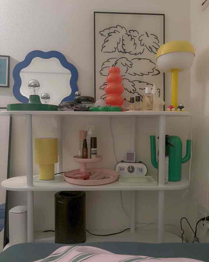 White background 1K single household room featuring yellow lamps, poster, and objet decor on shelving
