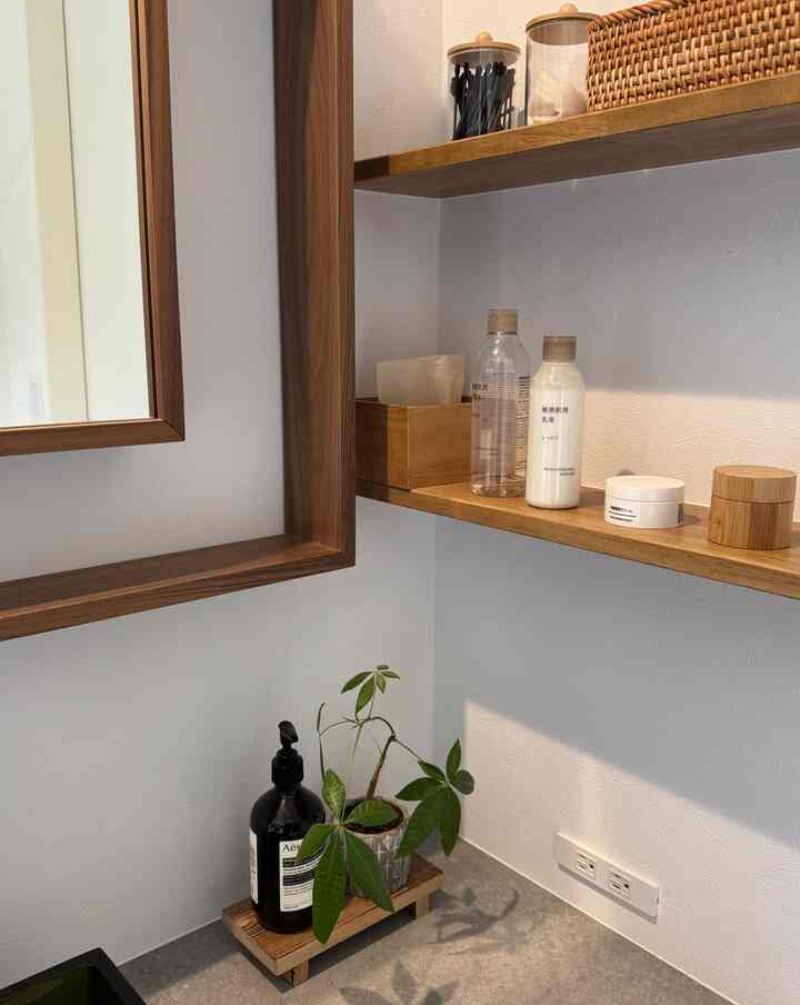 Natural color wood-tone washstand area featuring mirror and organized bathroom accessories in a simple, clean powder room