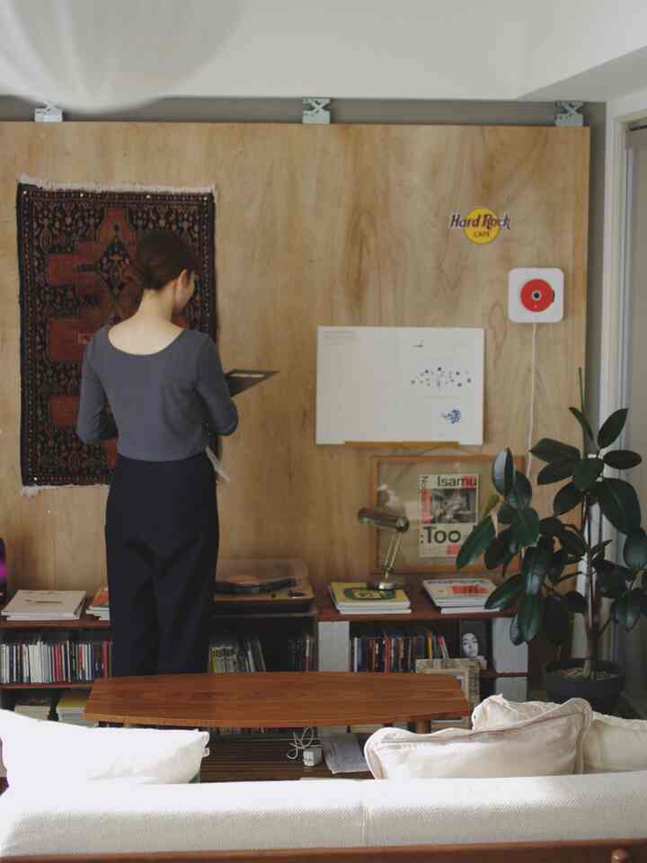 Vintage style living room with wood tone wall and white sofa, featuring vintage decor and green potted plant