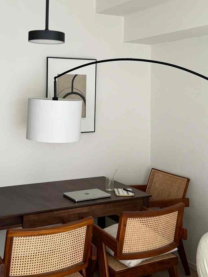 ナチュラルな色調のダイニング、木製のダイニングテーブルとラタンチェアが配置されたシンプルで落ち着いた雰囲気のインテリア