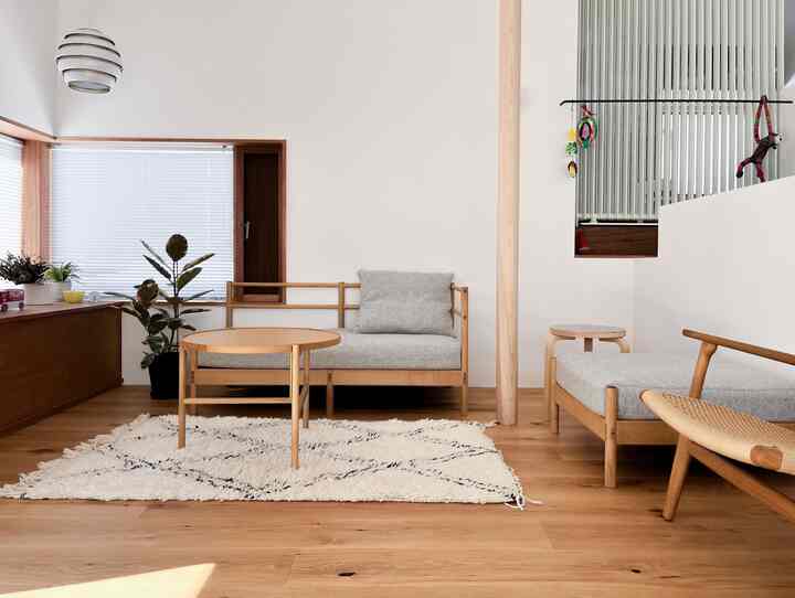 Natural tone living room featuring wooden furniture and gray cushions with simple, calm atmosphere