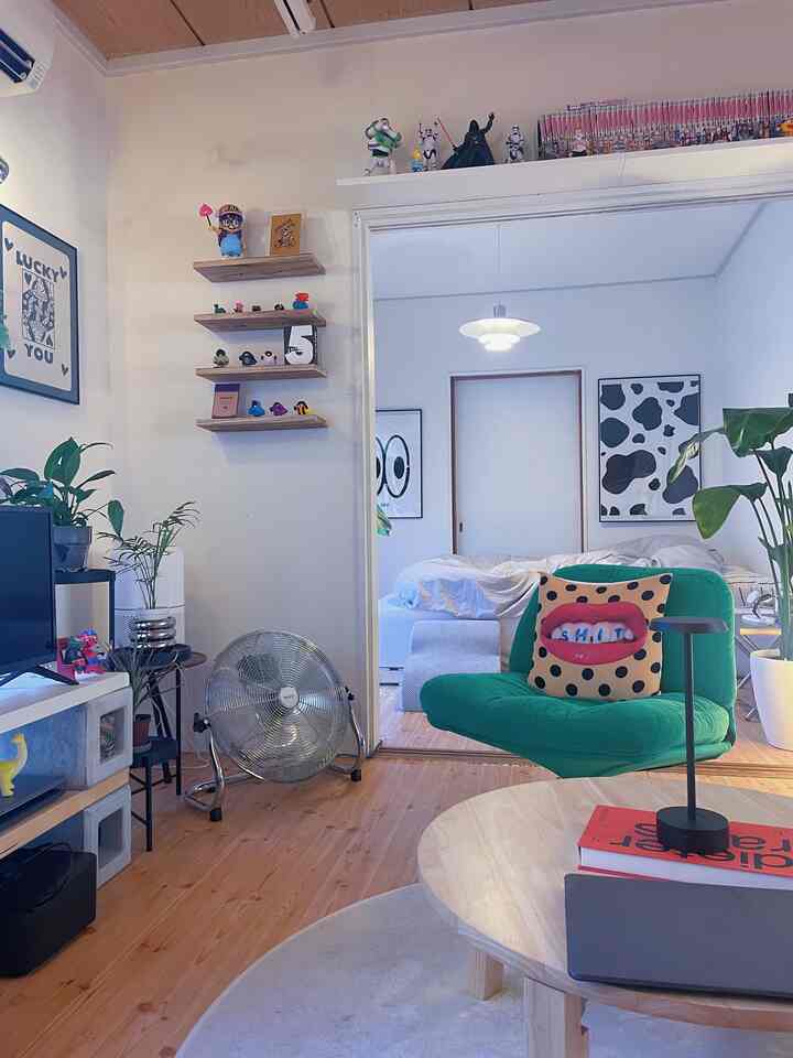 白と緑の落ち着いた色調のリビング、丸いコーヒーテーブルとオフィスチェアが配置されたナチュラルモダンなインテリア