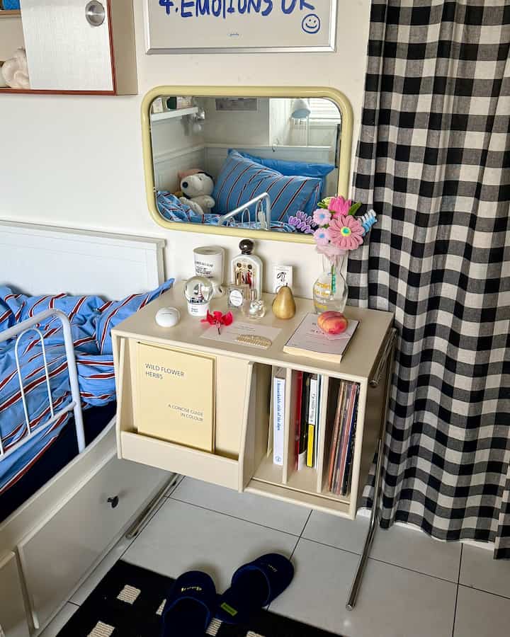 Beige and black toned bedroom featuring a side table with mirror and storage, creating a cozy atmosphere
