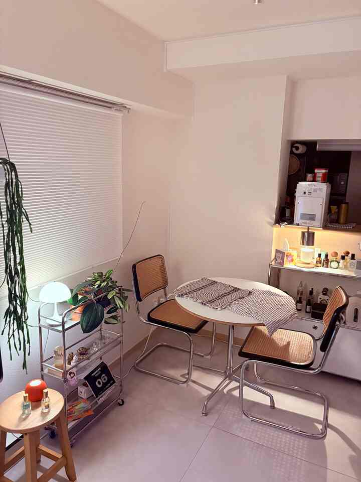 White and brown toned dining room featuring rattan chairs and round dining table with mid-century modern vibe