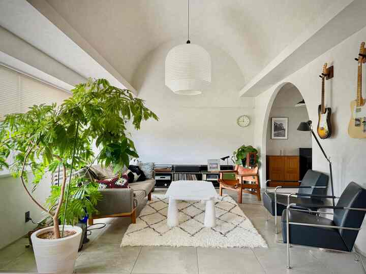 White-toned living room featuring mid-century modern sofa and armchairs with cozy atmosphere