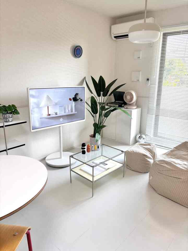 白とナチュラルカラーの調和が取れたリビング、モダンな家具と植物が配置された明るく清潔感のあるインテリア