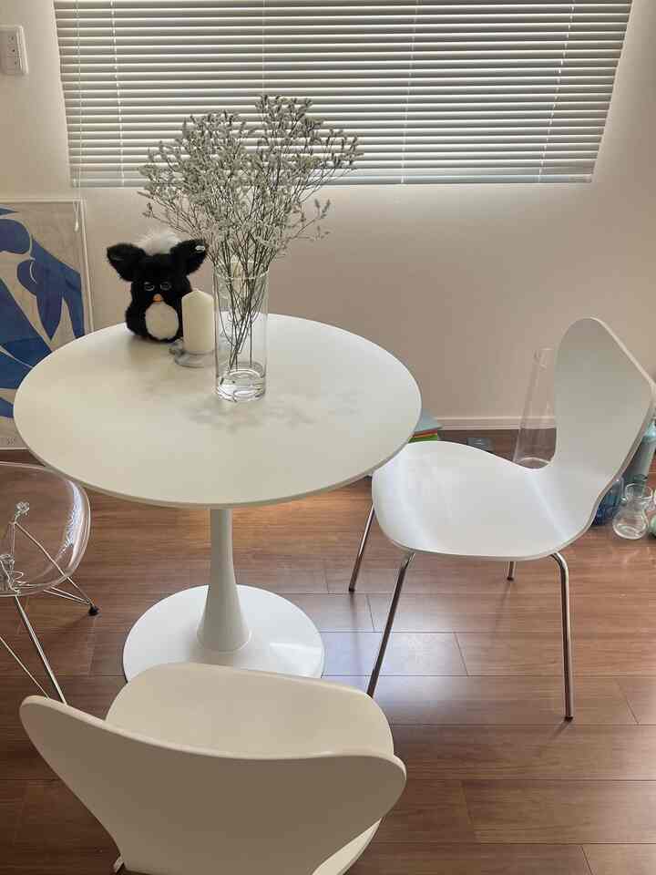 白とナチュラルトーンのワンルームダイニングスペース、シンプルなカフェ風のテーブルと椅子が配置された清潔感のあるインテリア