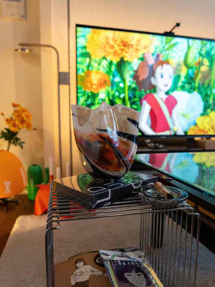 北欧とミッドセンチュリースタイルが融合したリビング、レトロなガラス花瓶とワイヤーシェルフ、フロアランプが配置された雰囲気のあるインテリア