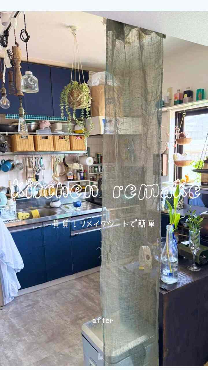 A cozy modern kitchen in navy tones featuring remodeled cabinets and a sheer curtain dividing the space