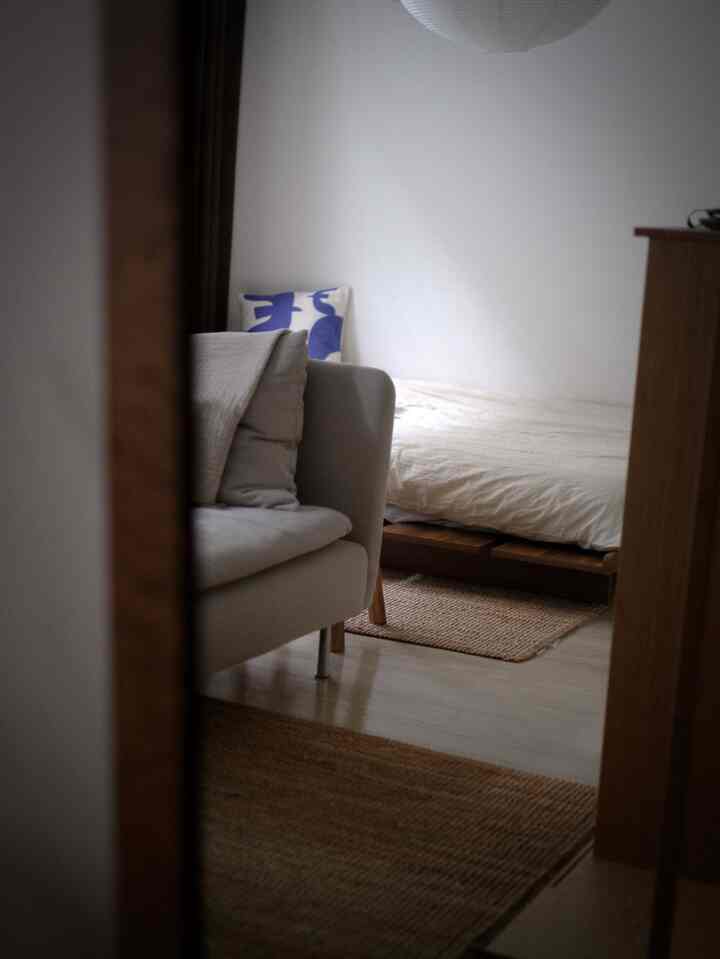 Natural toned bedroom featuring beige bedding, wood tone furniture, and rugs creating a cozy space