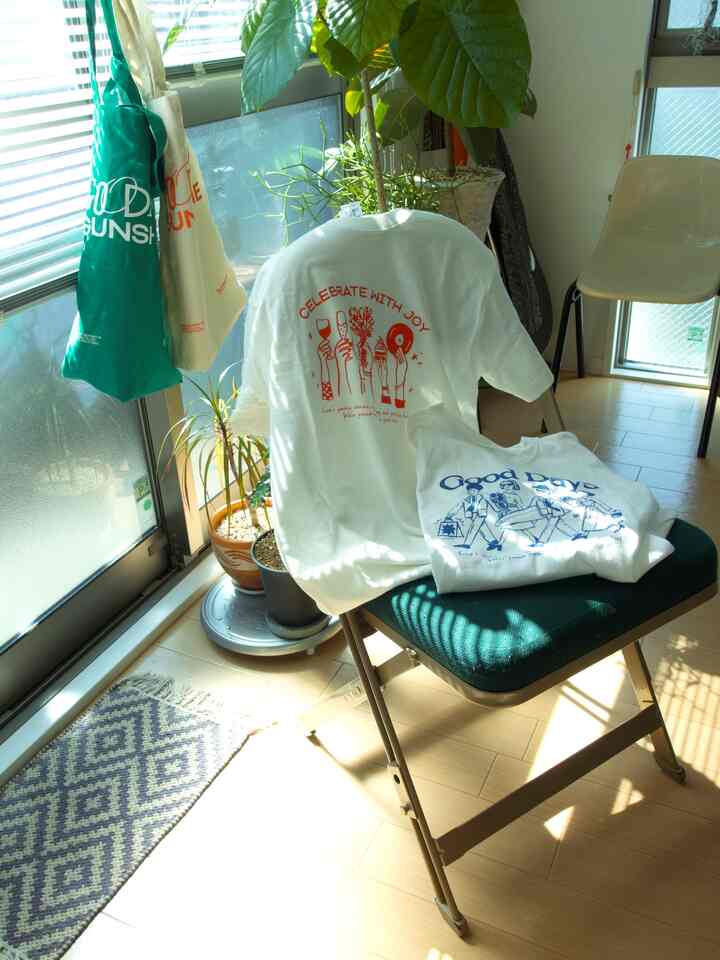 Bright white and blue toned single household living room featuring plants and a mid-century modern style folding chair in a cozy space