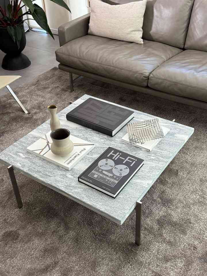 グレー調のリビング、レザーソファと大理石のコーヒーテーブルが配置されたモダンで落ち着いた空間