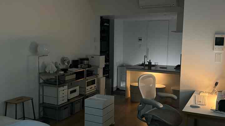 ホワイトとグレーの色調の小さなキッチンとホームオフィス空間、ミニマルでシンプルな家具が配置された雰囲気のあるインテリア