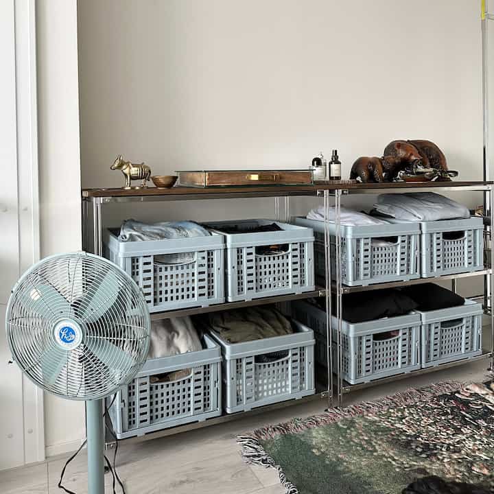 Light gray and natural wood-toned storage area featuring organized shelves with a clean, minimal layout