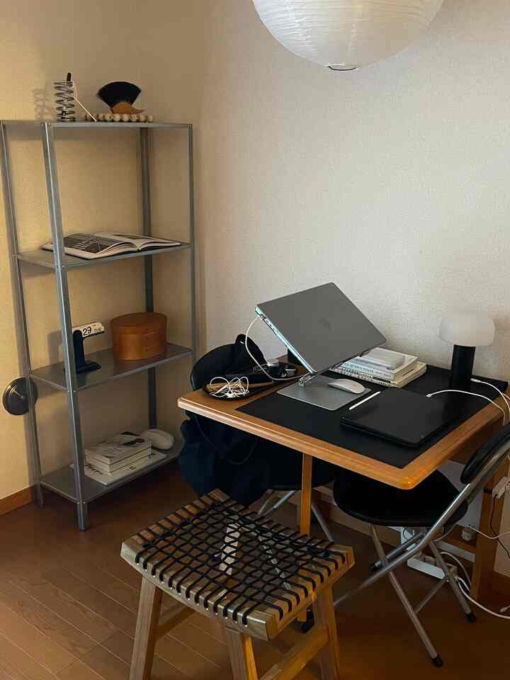 木目調の床と家具が配置されたワンルームのホームオフィス、シンプルで機能的な雰囲気のあるインテリア