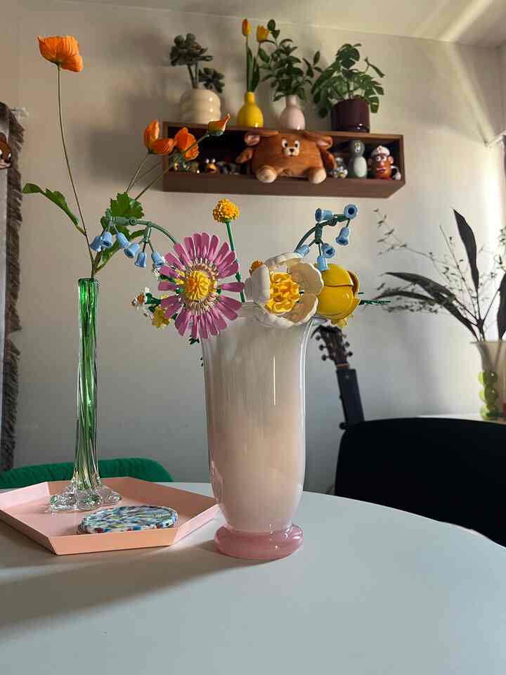 ピンクとグリーンのトーンが映える1LDKのリビング、花瓶と植物が調和した印象的なミッドセンチュリーモダンのインテリア