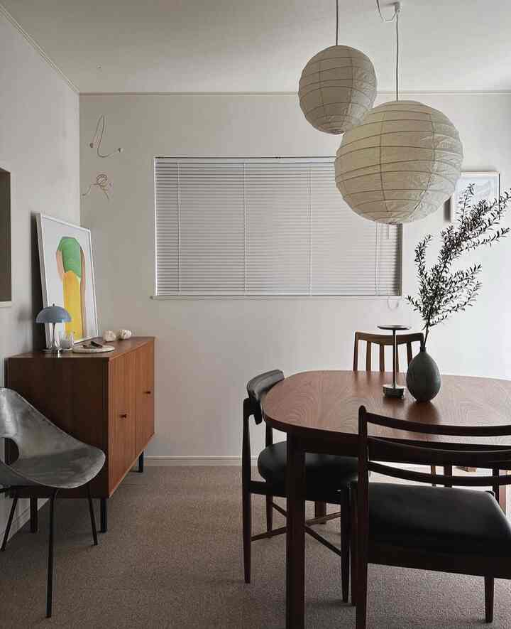 白い壁と木目調の家具が調和したミッドセンチュリーモダンなダイニング、落ち着いた雰囲気の空間