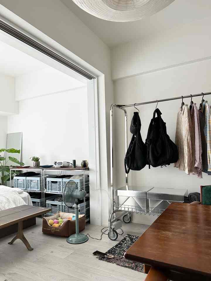 白と茶色のトーンのリビングルーム、ダイニングテーブルとクローゼットが配置されたナチュラルモダンなインテリア