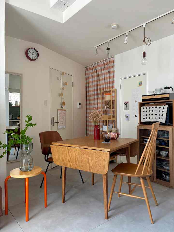 白い壁とナチュラルな木目調のダイニングテーブルが配置されたシンプルで清潔感のあるダイニングルーム