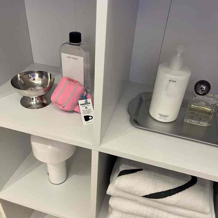 White-toned shelves featuring Korean interior style cosmetics and towels in a neat natural modern space
