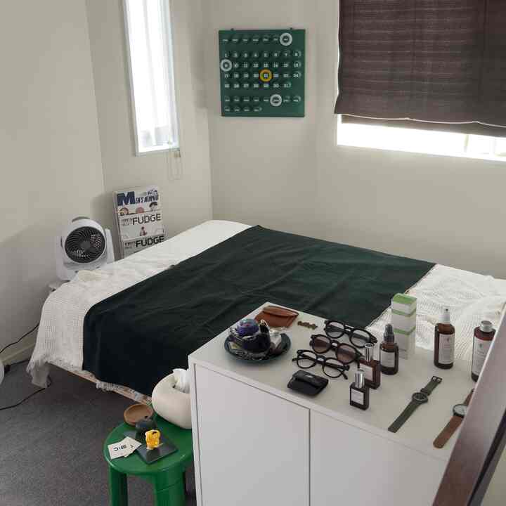 ホワイトとグリーンの配色が特徴的な6畳の寝室、整ったベッドと収納キャビネットが配置された落ち着いた空間