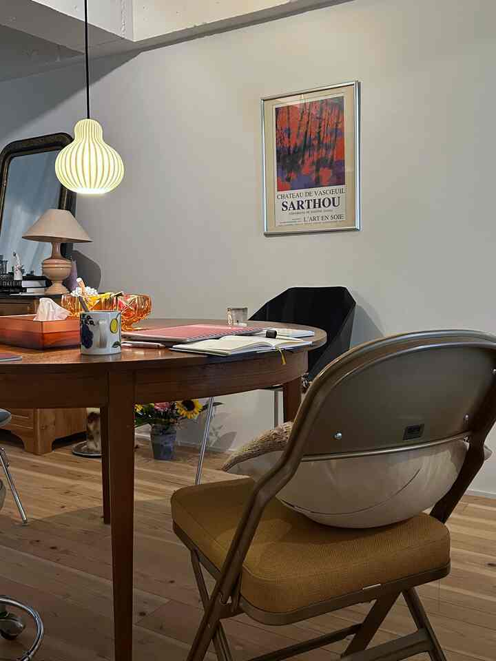 柔らかな木目調とブラウン色のダイニング、ミッドセンチュリーモダンの食卓と椅子が配置された印象的な空間