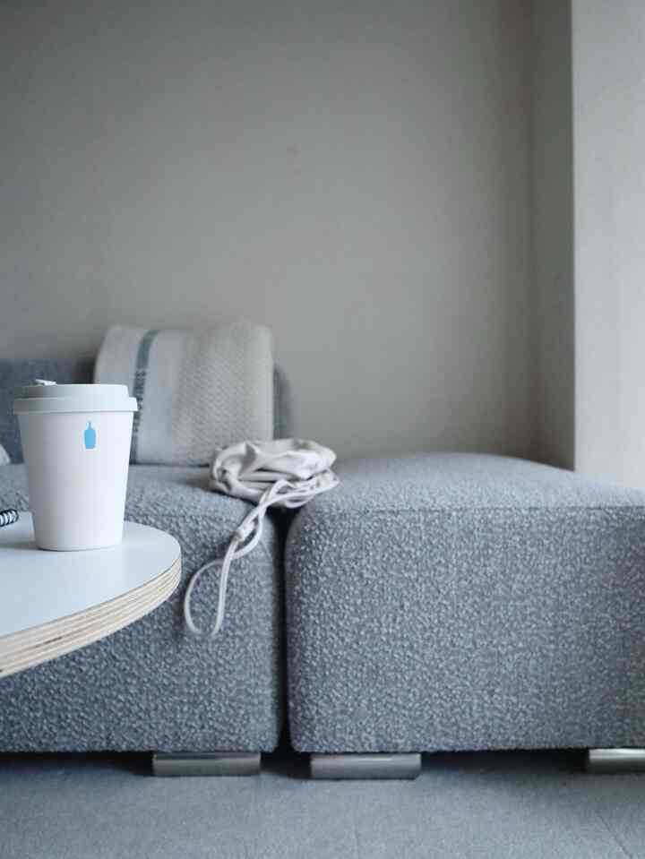 グレーのコーナーソファと白いコーヒーテーブルが配置されたシンプルなリビングのインテリア