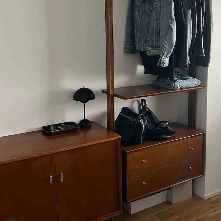 ブラウンの木目調キャビネットとホワイトの壁が調和する収納空間、シンプルで実用的なクローゼット構成