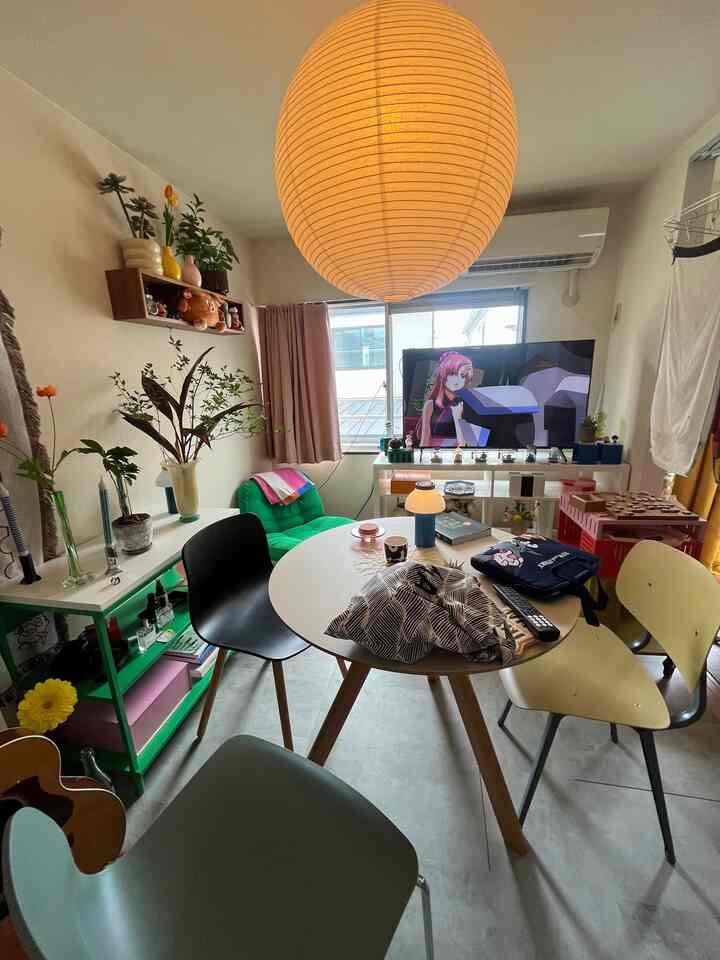 白い壁と天井を背景に、カラフルな家具と照明が配されたミッドセンチュリーモダンな1LDKのリビング空間