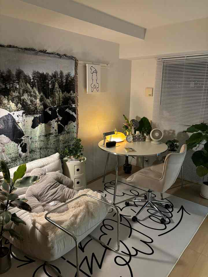 White-toned living room featuring a round dining table and sofa in a cozy Mid-Century Modern style setting