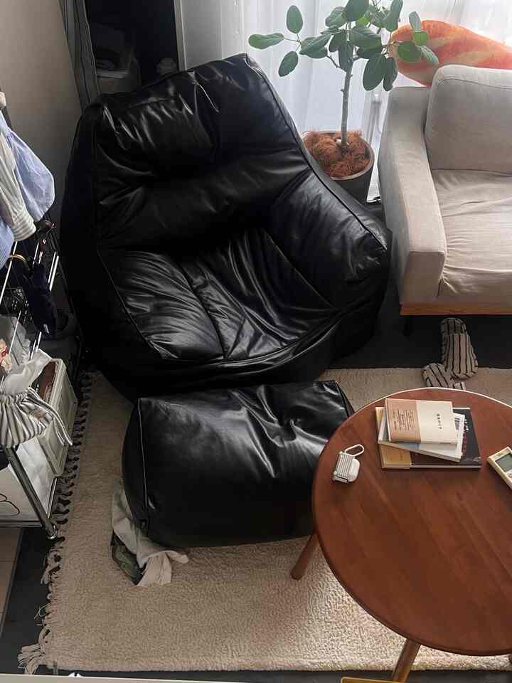 フレンチブラックとホワイトトーンのロフトリビング、ビーズクッションソファとベージュのアームチェアが配置された雰囲気のある空間