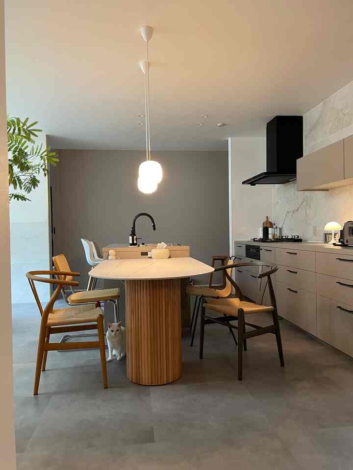 Natural color toned dining room featuring pendant lights and wooden dining chairs creating a cozy and clean atmosphere
