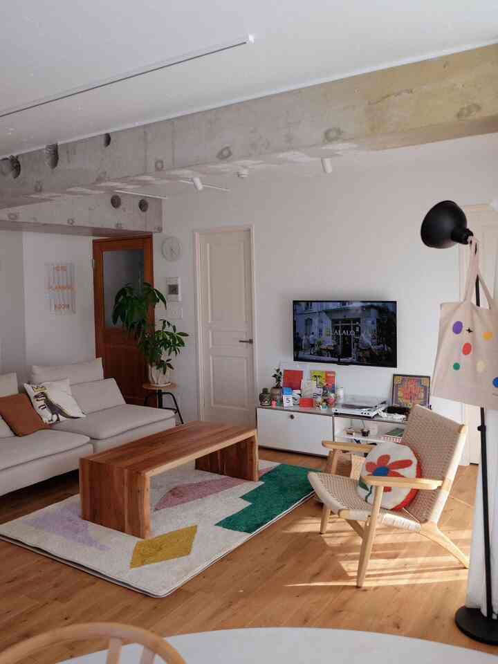 2LDK living room with white walls and wood tones, featuring natural modern sofa and armchair in a cozy setup